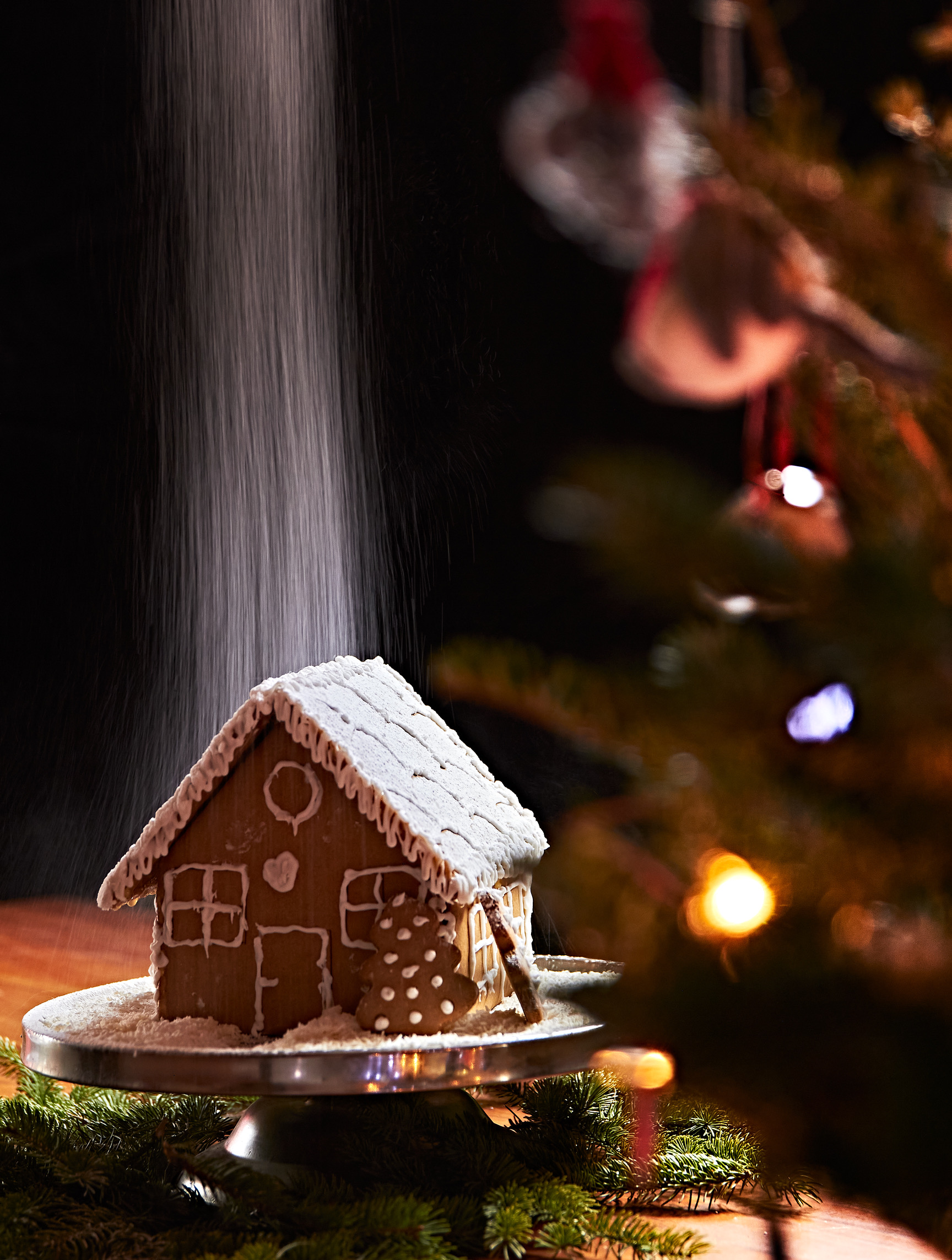 Christmas gingerbread house decorated with icing and powdered sugar snow
